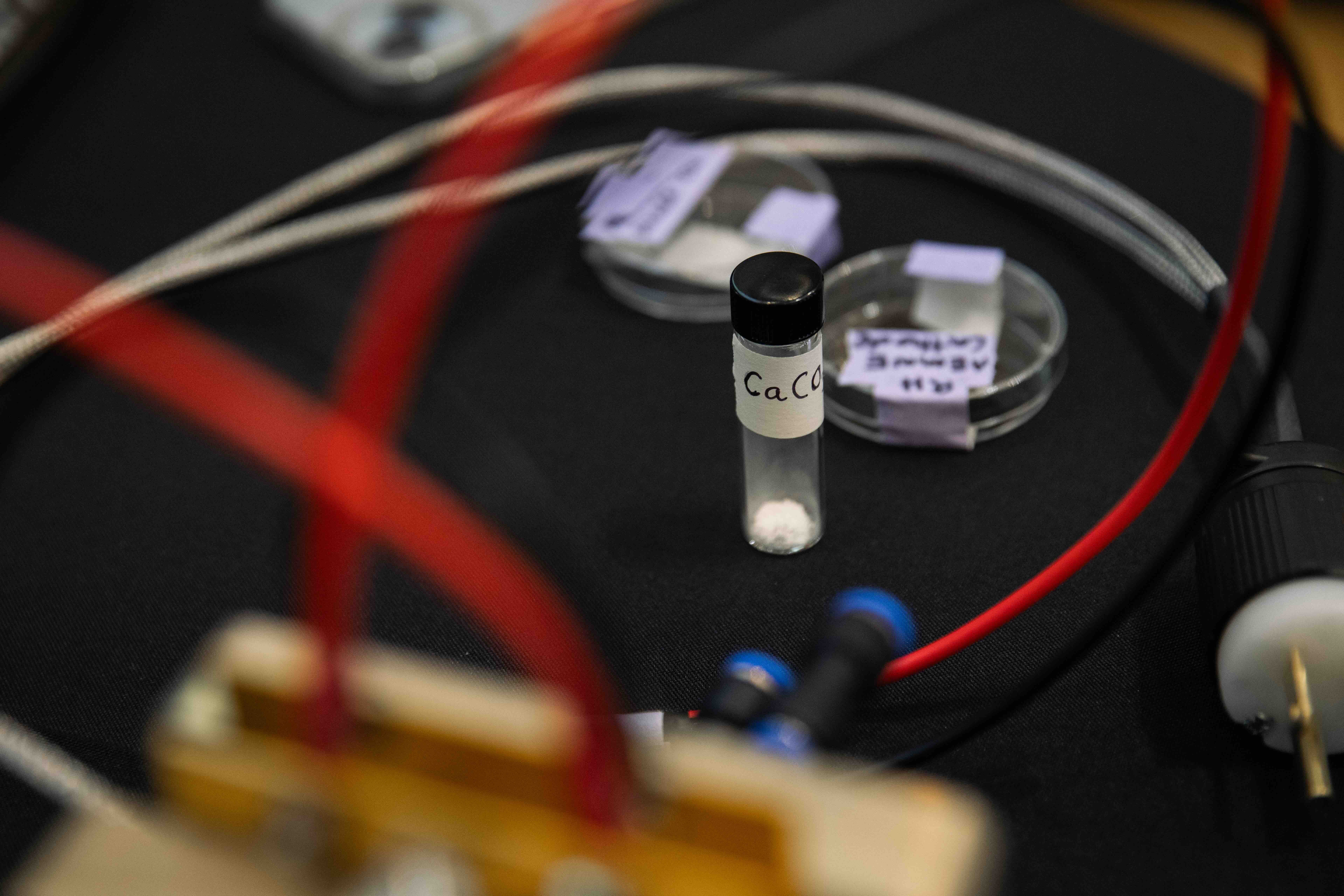 Various wires, petri dishes, and a labeled vial containing a clear liquid.