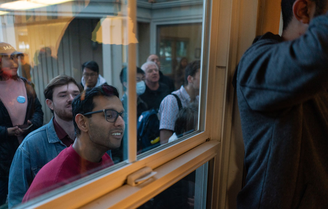 Onlookers viewing through a window