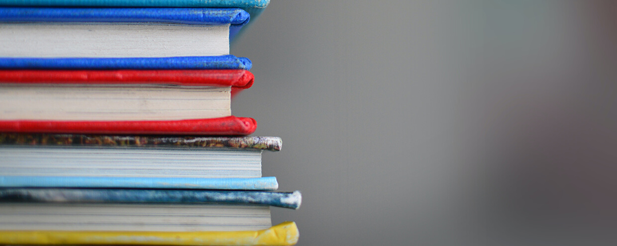 Close-up view of colorfully bound books stacked on top of one another.